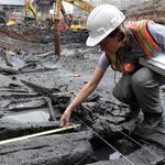 An archaeologist examines the hull found at the World Trade Center site